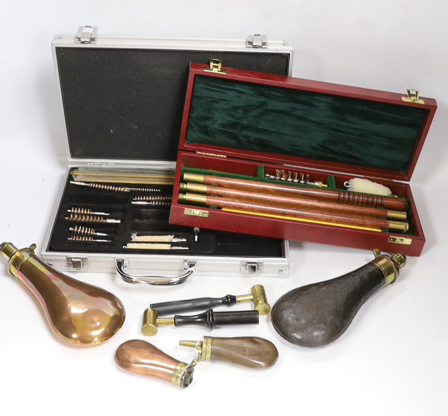 Three copper powder flasks, a leather powder flask, two powder measures and two cases of cleaning tools
